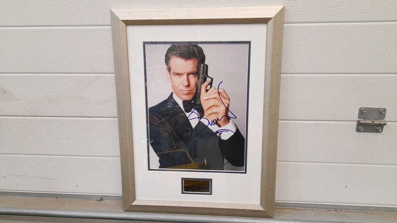 Lot 595 - FRAMED SIGNED PHOTO OF PIERCE BROSNAN  AS JAMES BOND 21"X17"