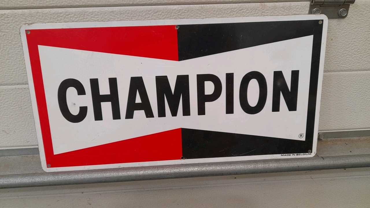 Lot 279 - CHAMPION TIN SIGN  19" X 9.5" NEW OLD STOCK