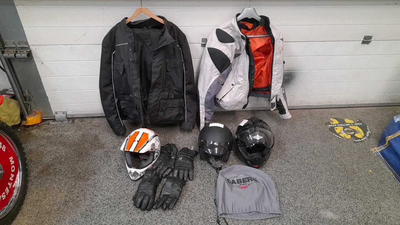 Lot 696 - 3 HELMETS , 1 JACKET GREY, JACKET & TROUSERS IN BLACK I PAIR OF GLOVES