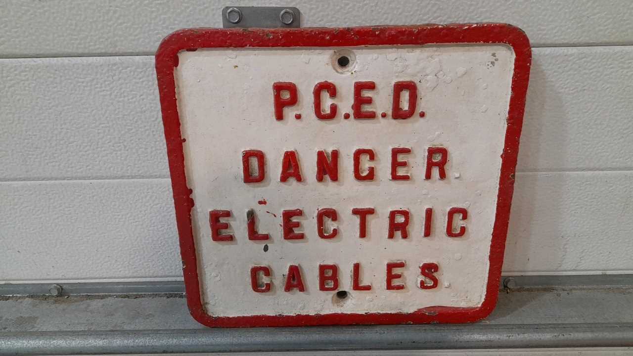 Click for high resolution Lot 95 - CAST IRON P.C.E.D DANGER ELECTRIC CABLES SIGN 12" X 11"